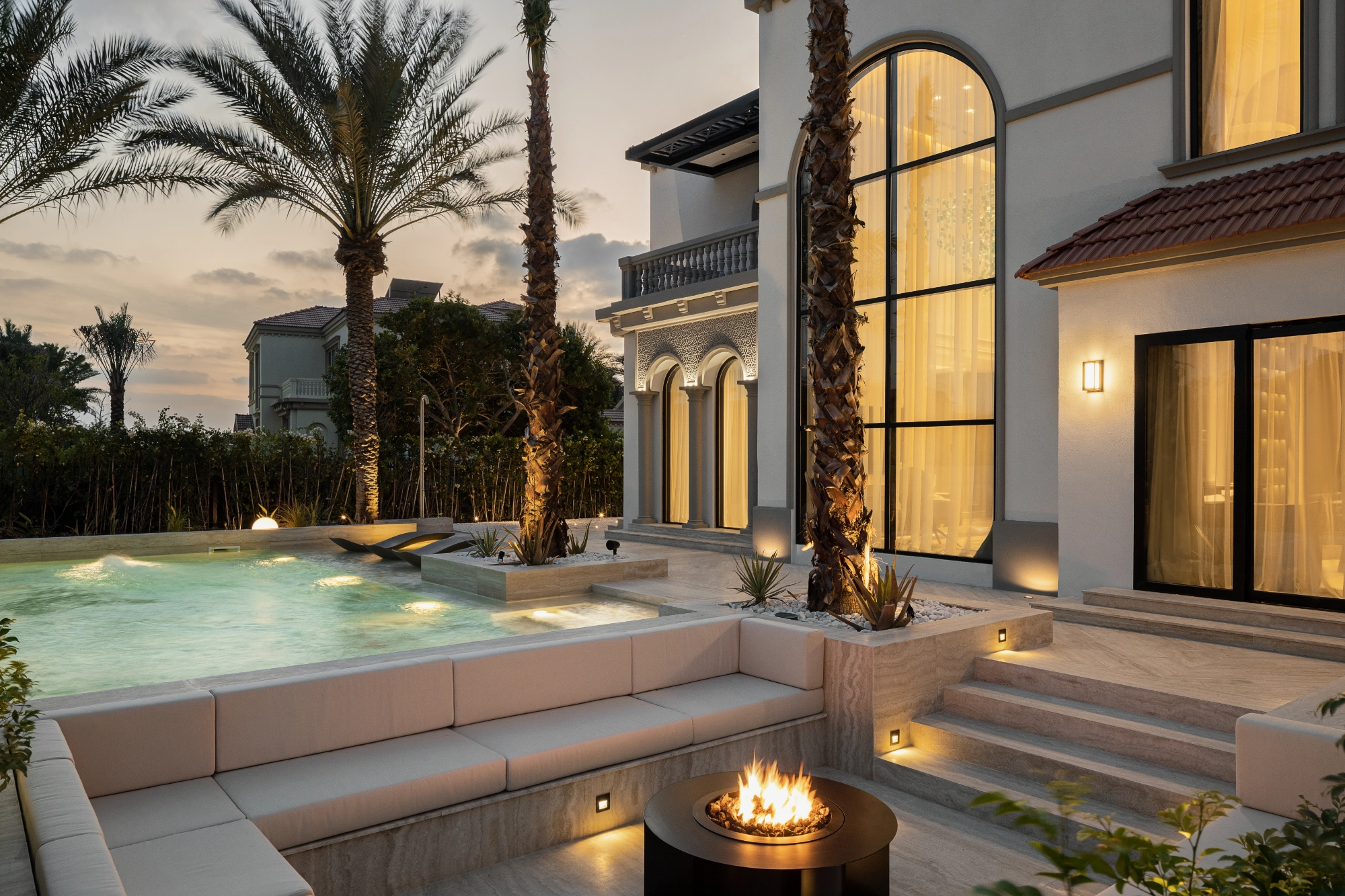 Pool terrace with fire pit at dusk